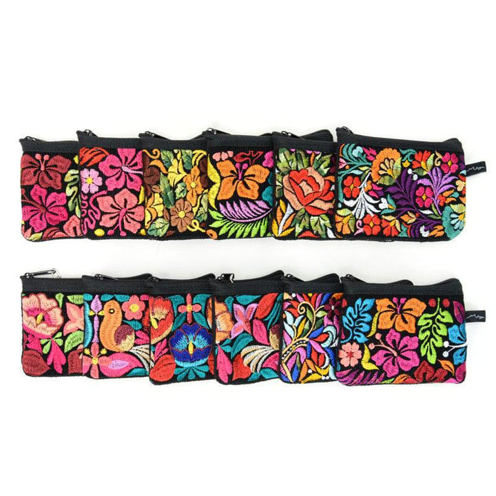 A collection of vibrant, multicolored coin purses with floral and animal patterns, displayed in rows on a white background.